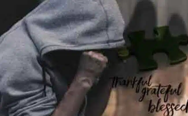 Person in hooded sweatshirt, puzzle piece overlay, words “thankful, grateful, blessed.” (AI-generated)