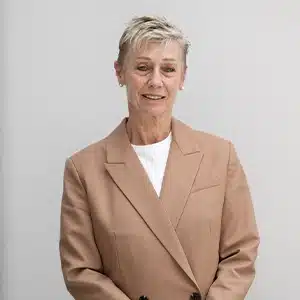 Professional woman in a tan blazer against a neutral background. (AI-generated)