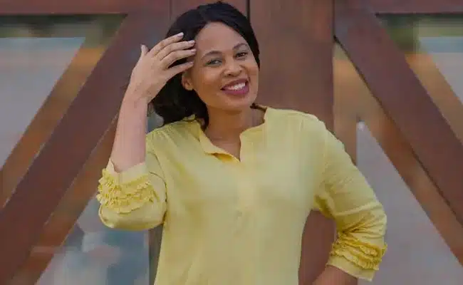 Smiling woman in a yellow blouse posing confidently outdoors. (AI-generated)