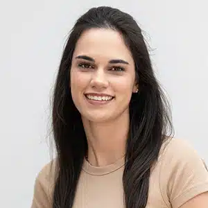 Smiling woman with long dark hair in a beige shirt against a neutral background. (AI-generated)